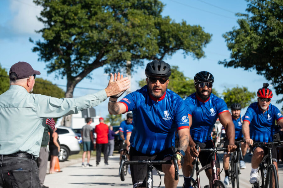 a group of men riding bikes down a street