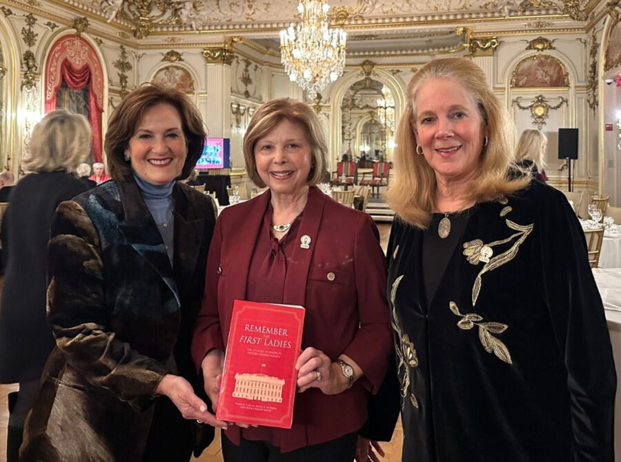 three women standing next to each other in a room