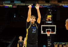 a young man standing on top of a basketball court