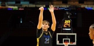 a young man standing on top of a basketball court
