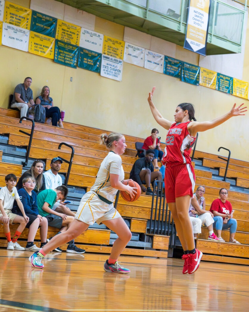 a group of young women playing a game of basketball