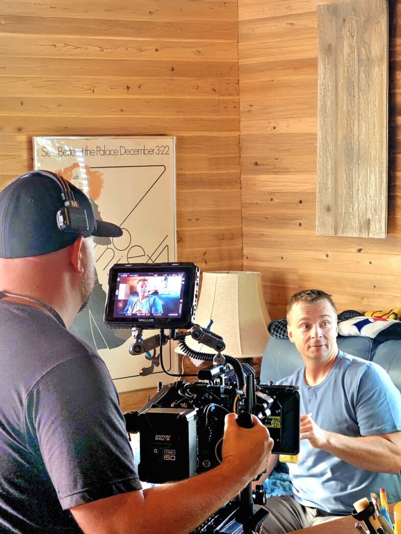 a man is filming another man on a video camera