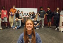 a woman sitting on the floor in front of a group of people