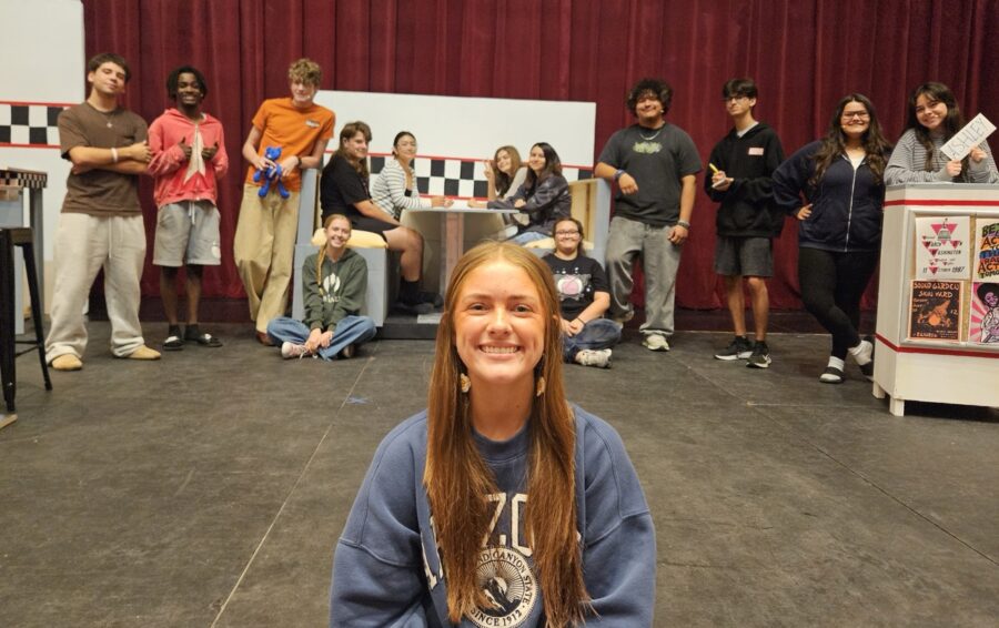 a girl sitting on the floor in front of a group of people