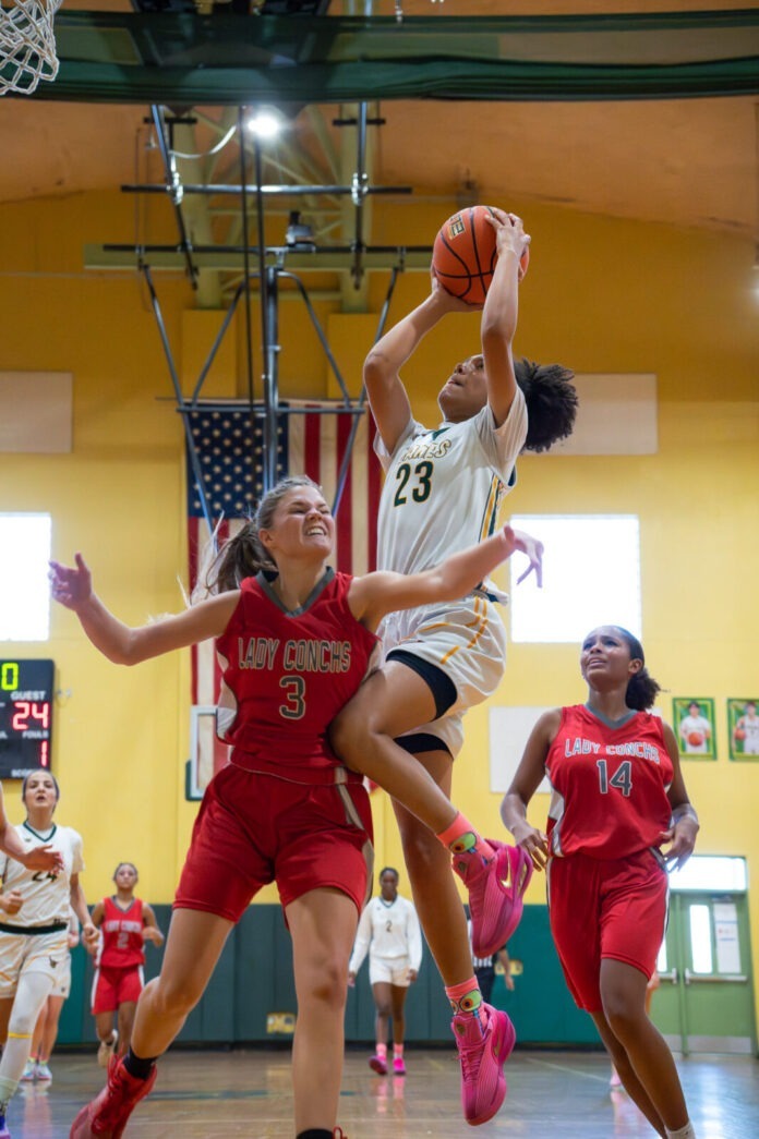 a group of young women playing a game of basketball