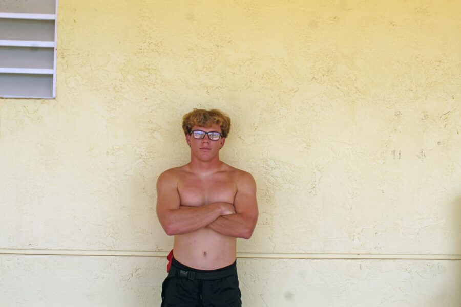 a man standing in front of a wall with his arms crossed