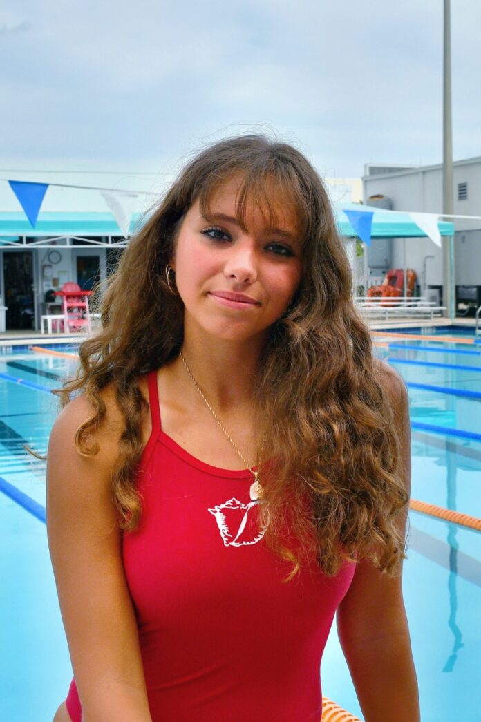 a woman standing in front of a swimming pool