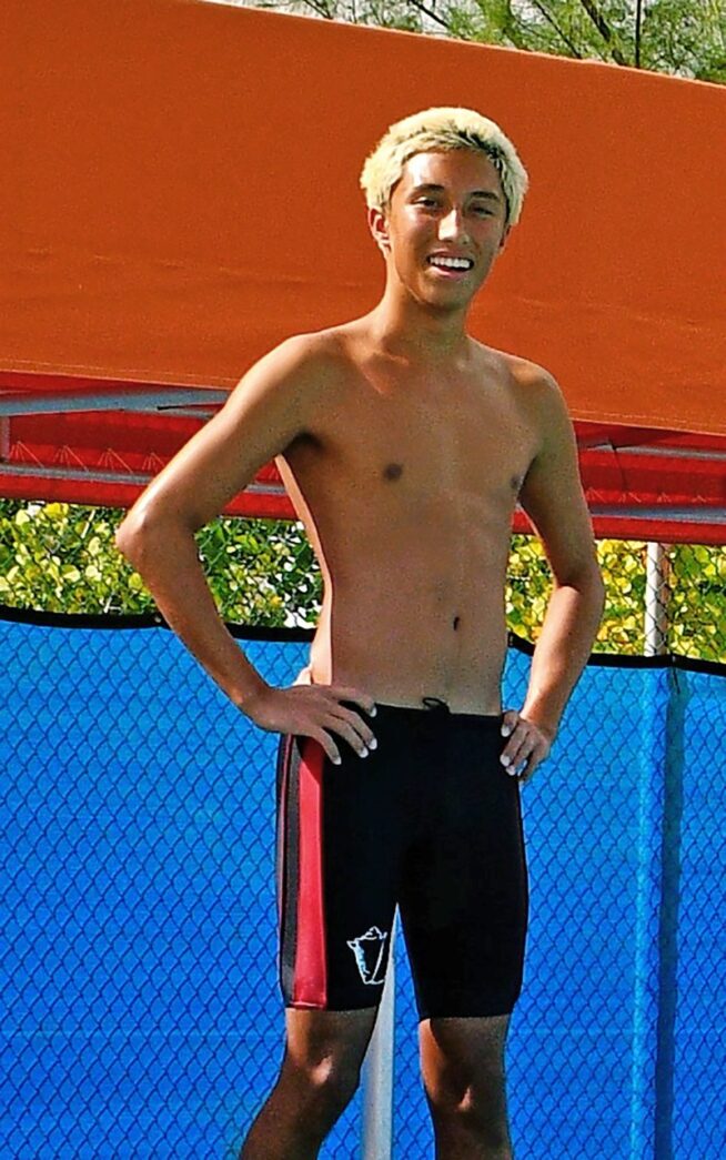 a man standing on a tennis court with his hands on his hips