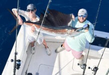 a couple of people on a boat with some fish