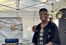 a man playing a musical instrument under a tent