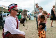 a man holding an owl in his right hand