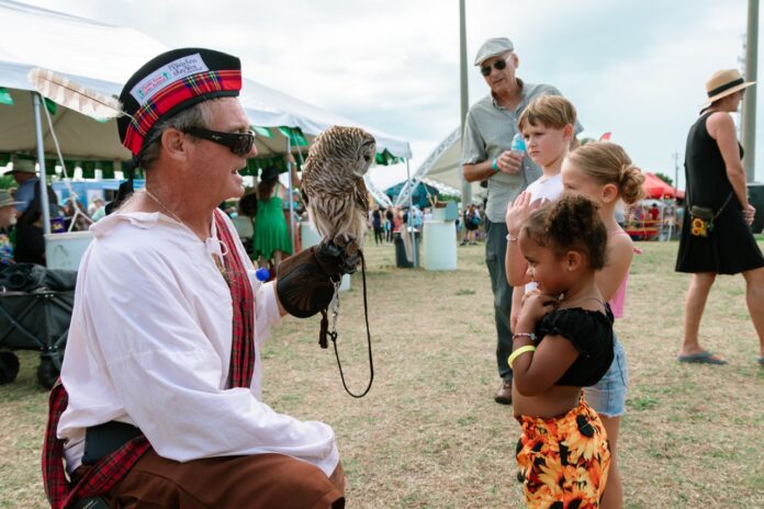 a man holding an owl in his right hand