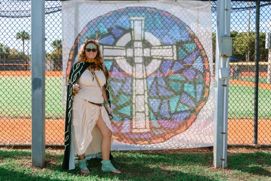 a woman standing in front of a stained glass window