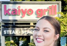 a woman standing in front of a restaurant sign