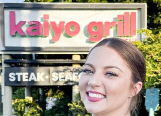 a woman standing in front of a restaurant sign