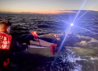 THREE RESCUED AFTER BOAT CAPSIZES OFF MARATHON a person on a small boat in the water
