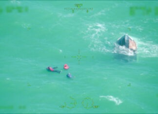 a couple of people in the water with a boat