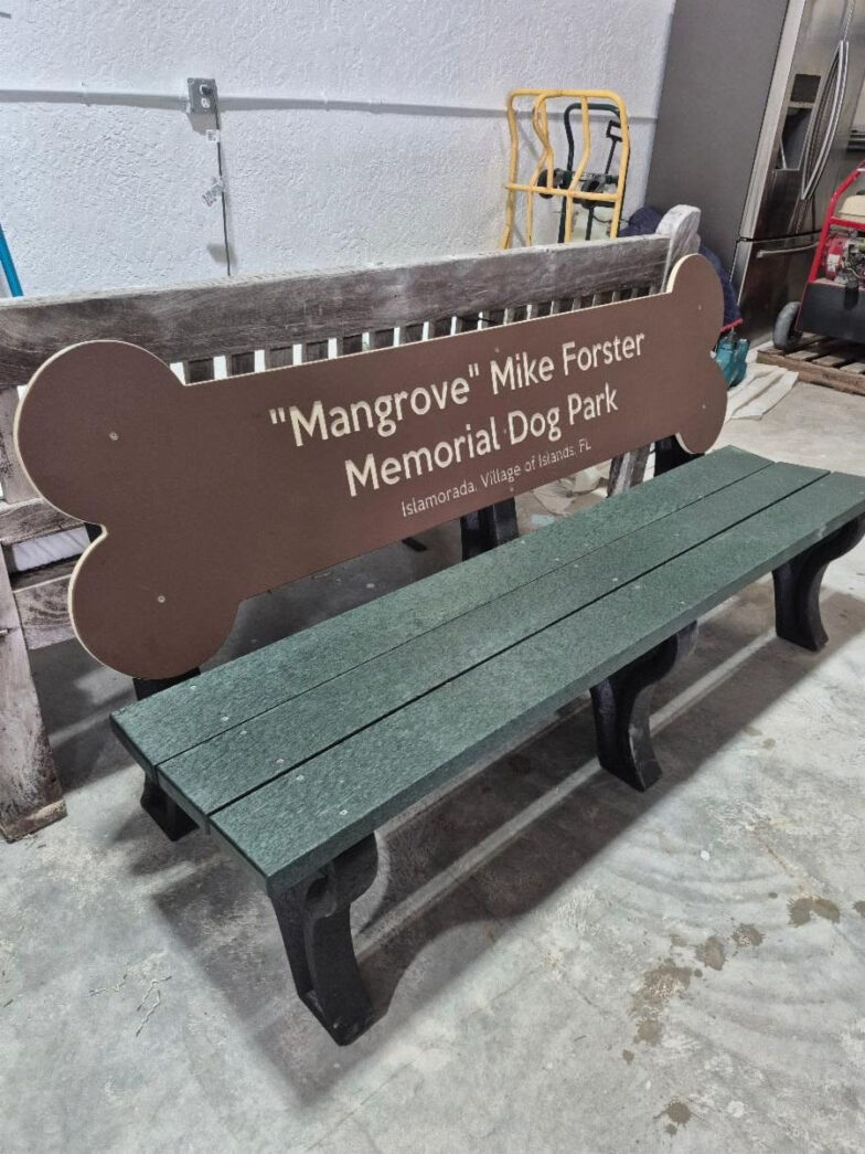 a park bench with a dog bone sign on it