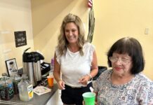 a couple of women standing in a kitchen