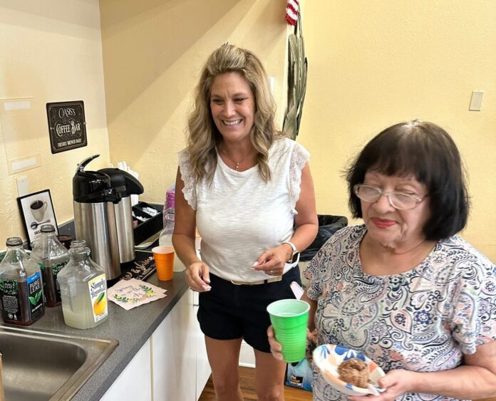 a couple of women standing in a kitchen