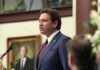 COULD PROPERTY TAX RELIEF COME AT THE EXPENSE OF PROVIDING ESSENTIAL SERVICES? a man standing at a podium in front of a microphone