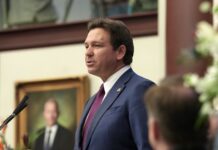 a man standing at a podium in front of a microphone