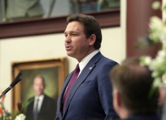 a man standing at a podium in front of a microphone