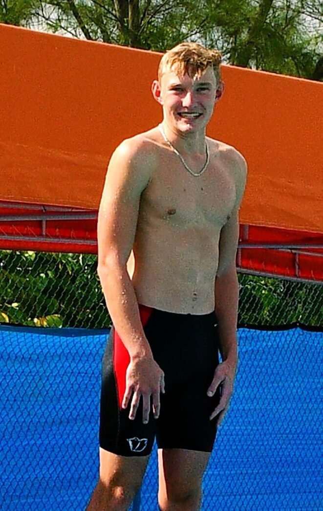 a shirtless man standing on a tennis court