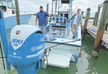 PREMIER BOAT SHOW RETURNS TO HAWK’S CAY two men standing on a boat in the water