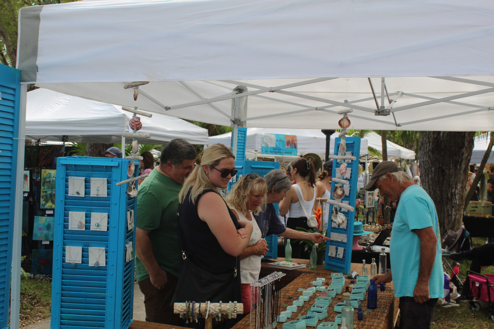a group of people standing around a table with cupcakes on it