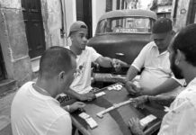 a group of men sitting around a table playing a game