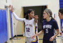 a group of young women playing a game of basketball