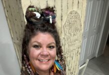 a woman with dreadlocks standing in front of a door