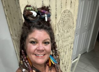 a woman with dreadlocks standing in front of a door