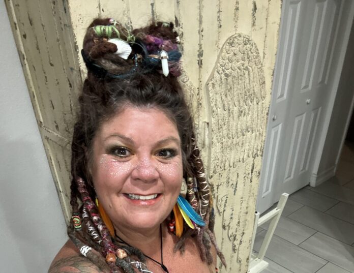 IMG_5154 a woman with dreadlocks standing in front of a door