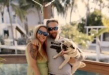 a man and a woman pose for a picture with a dog