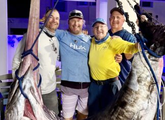 DUCK KEY CREW PULLS IN 400-POUND SWORDFISH a group of men standing next to a large fish