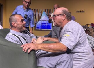 a group of men sitting around a living room together