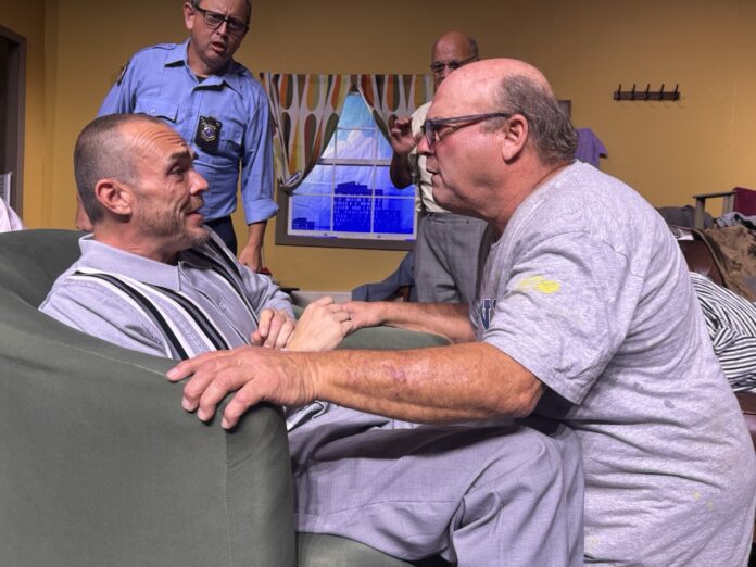 a group of men sitting around a living room together
