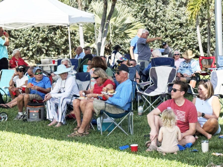 a group of people sitting in chairs under a tent