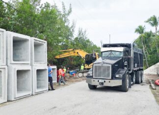 a large truck driving down a road next to a construction site