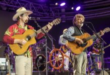 IN PICTURES: JIMMY BUFFETT’S CORAL REEFER BAND KEEPS THE PARTY GOING two men are playing guitars and singing on stage