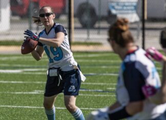 ANNUAL WOMEN’S FLAG FOOTBALL TOURNAMENT RETURNS TO KEY WEST THIS WEEKEND a woman holding a football on top of a field