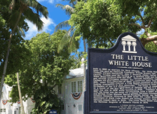 LADIES FIRST: SPECIAL EVENT FOCUSES ON FIRST LADIES a sign in front of a fence that says the little white house