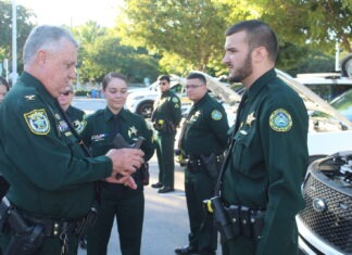 a group of police officers standing around a car