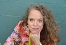 a woman sitting at a table with a glass of wine