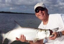 a man holding a fish on a boat