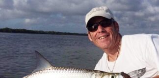 a man holding a fish on a boat