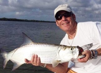 VILLAGE SET TO DEDICATE FOUNDERS DOG PARK AFTER THE LATE MIKE FORSTER ON SUNDAY a man holding a fish on a boat