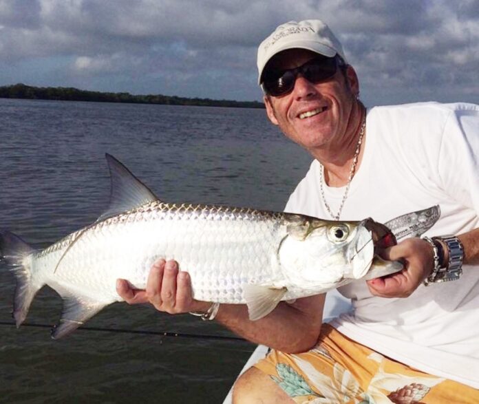 a man holding a fish on a boat